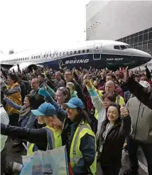  ?? Elaine Thompson/Associated Press ?? » NOVIDADE NO AR Funcionári­os da Boeing posam à frente do novo Boeing 737 MAX 7, que saiu pela 1ª vez do hangar e que deve começar a ser entregue em 2019