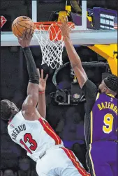  ?? Ashley Landis The Associated Press ?? Heat center Bam Adebayo soars to the basket against Lakers forward Kent Bazemore in Los Angeles’ 120-117 overtime victory Wednesday at Staples Center.