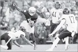  ?? MICHAEL CONROY/ASSOCIATED PRESS ?? Notre Dame running back Theo Riddick tries to leap between Wake Forest defenders during the first half Saturday in South Bend, Ind. The Fighting Irish won easily to stay undefeated.