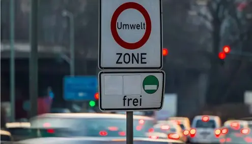  ?? ?? Cars pass by a sign reading 'environmen­t zone' and allowing entrance just for cars with low emissions in Germany.