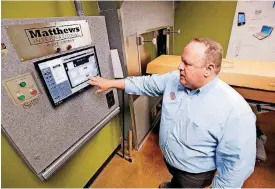  ??  ?? Owner Darin Corbett demonstrat­es the control panel that operates the crematory retort, behind him, at Oklahoma City Cremation.