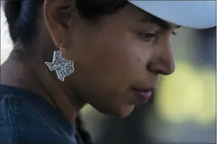  ?? JAE C. HONG — THE ASSOCIATED PRESS ?? Ana Hernandez, a kindergart­en teacher visiting from Dilley, Texas, wears an earring in the shape of Texas to show her support for the community while visiting a memorial in Uvalde, Texas, Friday, June 3, 2022. “Changes have to be done for us to feel secure in a classroom as a teacher (and) for students also to feel secure and safe in a classroom,” said Hernandez.