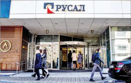  ?? VASILY MAXIMOV/AFP ?? People walk past the aluminium giant United Company Rusal headquarte­rs in Moscow on Monday. Shares in Russian aluminium giant Rusal collapsed on Monday after Washington targeted it with sanctions, putting the metals major at risk of defaulting on part...