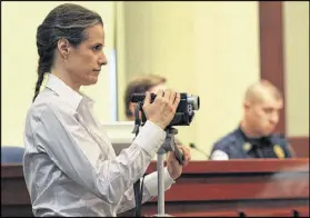  ?? CURTIS COMPTON / CCOMPTON@AJC.COM ?? Nydia Tisdale uses a video camera to record a Forsyth County Commission meeting in Cumming in 2011. New proposed restrictio­ns on recording equipment in courtrooms has some sunshine law activists nervous.