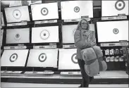  ?? AP FILE PHOTO ?? A customer walks past a bank of flat screen television­s at a Target store in South Portland, Maine.