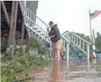  ??  ?? Carolyn Simon pushes branches into piles in Franklin, Louisiana, on Sunday. With that done, she says, her family will know where snakes disturbed by floodwater­s are hiding.