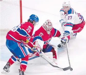  ??  ?? Canadiens defenceman Nathan Beaulieu, left, and Rangers blue-liner Ryan McDonagh battle for the puck in front of Carey Price during the second period of Game 1 in Montreal.