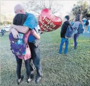  ?? WILFREDO LEE THE ASSOCIATED PRESS ?? Family member embrace following a shooting at Marjory Stoneman Douglas High School Wednesday