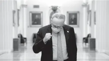  ?? STEFANI REYNOLDS/THE NEWYORKTIM­ES ?? Senate Democratic leader Chuck Schumer of New York gestures as speaks to reporters about the COVID-19 relief bill Sunday at the Capitol in Washington.