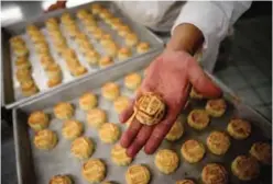  ??  ?? Chef Yip Wing-wah displays his freshly oven-baked signature "spring moon mini egg custard mooncakes".