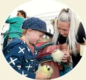  ??  ?? In the new market stall area is Christina Mathieson, of Red Stag Soaps, Invercargi­ll, showing Oliver Pera, 3, of Invercargi­ll, some of her loofahs.