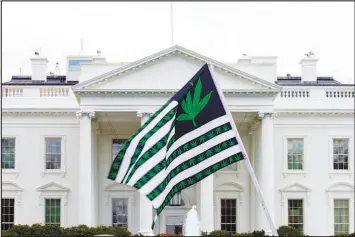  ?? JOSE LUIS MAGANA / ASSOCIATED PRESS FILE (2016) ?? A demonstrat­or waves a flag with marijuana leaves depicted on it outside of the White House during an April 2, 2016, protest calling for the legalizati­on of marijuana.