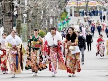  ??  ?? Young women wearing kimonos walk towards their ‘Coming-of-Age Day’ ceremony at the Toshimaen amusement park in Tokyo. — AFP photo