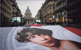  ?? Christophe Ena / Associated Press ?? Pictures of Josephine Baker and a red carpet lead to the Pantheon monument, rear, in Paris, France, on Tuesday, where Baker is to symbolical­ly be inducted, becoming the first Black woman to receive France’s highest honor. A coffin carrying soils from the U.S., France and Monaco will be deposited inside the Pantheon. Her body will stay in Monaco at the request of her family.