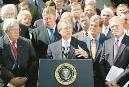  ?? RON EDMONDS/AP 2002 ?? President George W. Bush, surrounded by House leadership, announces a resolution authorizin­g the Iraq War. The Senate voted to repeal the measure Wednesday.