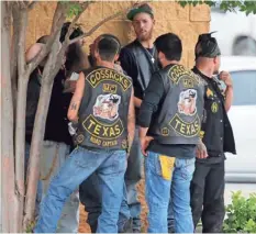  ?? ROD AYDELOTTE, AP ?? Bikers congregate against a wall while authoritie­s investigat­e a melee at a Twin Peaks restaurant Sunday in Waco, Texas.