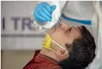  ?? AP file ?? A health worker takes a nasal swab sample at a Covid-19 testing camp organised for shopkeeper­s at a market in New Delhi. —