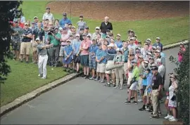  ?? Jeff Siner Charlotte Observer ?? RORY McILROY FINDS A HOLE after moving the gallery out of the way on the 10th hole, his first of the day. He made a par and wound up shooting 72.
