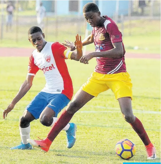  ?? FILE ?? Dinthill Technical’s Karim Bryan (right) shrugs off a challenge from Holy Trinity’s Phillion Lawrence during their ISSA Champions Cup encounter at the Stadium East field on Saturday, November 3, 2018.
