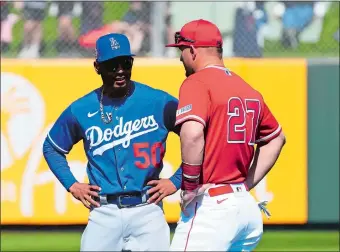  ?? ROSS D. FRANKLIN/AP PHOTO ?? The Dodgers’ Mookie Betts (50) and Angels’ Mike Trout (27) prior to a spring training baseball game on Friday in Tempe, Ariz. The crosstown rivals are two of the MLB stars who will be playing in the World Baseball Classic, which returns this week after a six-year absence.