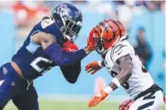  ?? AP PHOTO/GEORGE WALKER IV ?? Tennessee Titans running back Derrick Henry uses a stiffarm move on Cincinnati Bengals safety Nick Scott during the second half of Sunday’s game in Nashville.