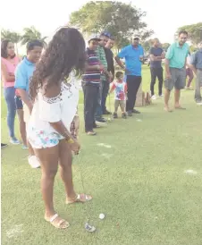  ??  ?? A young lady tries her hand at putting during the Lusignan Golf Club’s Innovative Greensome and Barbeque held last Sunday.