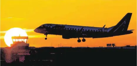  ?? FOTO: DPA ?? Ein Flugzeug landet bei Sonnenaufg­ang. Während unmittelba­r vor dem Ende des Air-Berlin-Flugbetrie­bs eine Transferge­sellschaft für die Mitarbeite­r der insolvente­n Fluglinie auf sich warten lässt, ist das Fliegen in Deutschlan­d und Europa noch einmal...