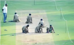  ??  ?? MUMBAI: Indian groundstaf­f scrub the surface of the pitch after the team training sessions at the Wankhede stadium ahead of the fourth Test cricket match between India and England in Mumbai yesterday. — AFP