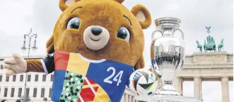  ?? ?? Teddy bear Albaert, the mascot of Euro 2024, poses with the UEFA Euro 2024 trophy as it goes on public display in front of the Brandenbur­ger Gate, Berlin, Germany, April 24, 2024.