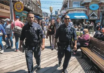  ?? Nick Otto / Special to The Chronicle ?? Officers Ali Misaghi (left) and Marcus Wells patrol Pier 39 on Monday. The city is adding patrols for tourist hubs including North Beach, Chinatown and Union Square.