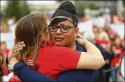  ?? JASON GETZ / AJC ?? Julvonnia McDowell, mother of a victim of gun violence, and Andrea Teichner hug after McDowell spoke at the Moms Demand Action rally Wednesday.