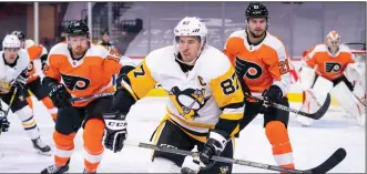  ?? (AP/Chris Szagola) ?? Sidney Crosby (middle) of the Pittsburgh Penguins chases the puck after winning a face off against the Philadelph­ia Flyers last month. A decade ago, Crosby’s career was at a crossroads because of an extended absence caused by a concussion. On the eve of his franchise-record 1,000th regular-season game, Crosby looks just as dangerous as ever.