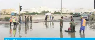  ??  ?? Ministry of Defense personnel help drain water from a submerged street.