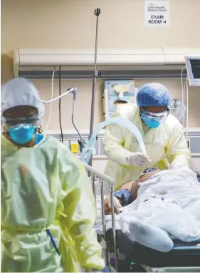  ?? JOHN MINCHILLO / THE ASSOCIATED PRESS ?? A respirator­y specialist operates a ventilator for a patient with COVID-19. People who spend time on ventilator­s generally experience cognitive deficits, says Adrian Owen.