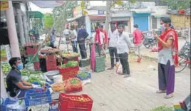  ?? MANOJ DHAKA/HT ?? ■
People gather at a vegetable shop in Rohtak on Wednesday.