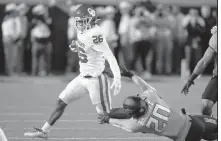  ?? AP/SUE OGROCKI ?? Oklahoma running back Kennedy Brooks (26) avoids a tackle by Oklahoma State safety Malcolm Rodriguez (20) in the first half on Saturday in Stillwater, Okla.