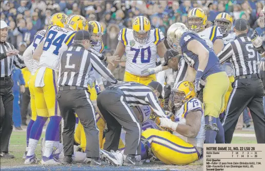  ?? | AP PHOTOS ?? Officials clear away players as they try to spot the ball after a carry by LSU holder Brad Kragthorpe on a fake field goal play in the first half on Tuesday. No touchdown was called, and the ball was spotted on the 1-yard line and turned over to Notre...