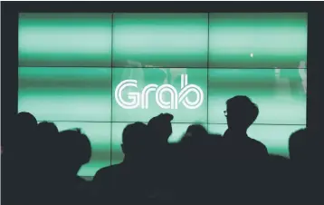  ??  ?? People wait for the start of ride-hailing company Grab’s fifth anniversar­y news conference in Singapore. — Reuters photo