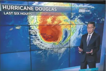  ?? The Maui News / TERRIE ELIKER photo ?? Hawaii News Now meteorolgi­st Guy Hagi reports on Hurricane Douglas as it passes by Maui County on the afternoon of July 26. Douglas, which packed maximum wind speeds of 130 mph, and Tropical Depression Boris, whose winds only reached about 35 mph, were the only two tropical cyclones in the Central Pacific this year.