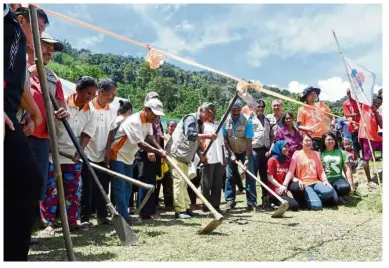  ??  ?? Move in the right direction: Dr Chow (centre) together with orang asli residents breaking ground at the location for the first orang asli medical outpost in Pos Lejang in Lipis. — Bernama