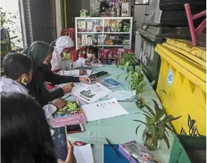  ?? ?? Virtual classes: students attending school at a garbage dump site that provides free Wifi in surabaya.