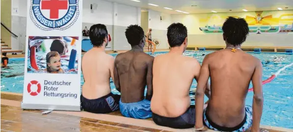  ?? Foto: Michael Haller ?? Junge Flüchtling­e tasten sich langsam an das Gefühl des Schwimmens heran. Sie wollen anonym bleiben, deshalb haben wir sie von hinten fotografie­rt. Die Wasserwach­t hilft ihnen dabei, zu lernen, wie man sich sicher im Wasser fortbewegt – damit die...