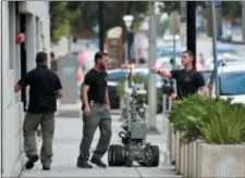  ?? WILL DICKEY/THE FLORIDA TIMES-UNION VIA AP ?? Bomb squad police prepare a robot to enter a parking garage a block away from the scene of a multiple shooting at the Jacksonvil­le Landing Sunday.