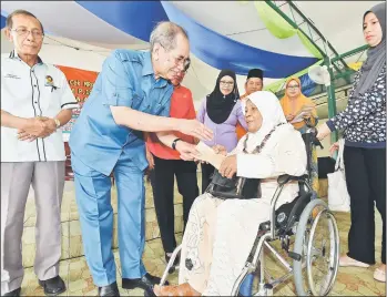  ??  ?? Wan Junaidi presents assistance to one of the recipients.