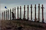  ?? AP PHOTO/ ERIC GAY, FILE ?? In this April 28, 1999, file photo, a woman stands among 15 crosses posted on a hill above Columbine High School in Littleton, Colo., in remembranc­e of the 15people who died during a school shooting on April 20. In the decades since Columbine, there’s been a growing call for media to avoid naming the gunmen in mass shootings. The idea is to avoid inspiring future shooters who seek infamy and notoriety.