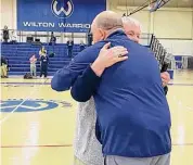  ?? Scott Ericson/Hearst Connecticu­t Media ?? Franey Donovan hugs Wilton basketball coach Joel Geriak after being honored for 30 years calling games at Wilton.