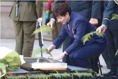  ??  ?? New Zealand’s Governor-General Patsy Reddy lays a fern at the Tomb of the Unknown Warrior during a sunset ceremony marking the 100th anniversar­y of the end of World War I, at the National War Memorial in Wellington. — AFP photo