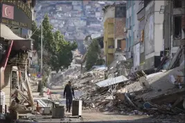  ?? UNAL CAM — THE ASSOCIATED PRESS ?? A man walks past destroyed buildings in Antakya, southeaste­rn Turkey, on Tuesday.
