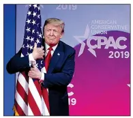  ?? AP/JOSE LUIS MAGANA ?? President Donald Trump embraces an American flag Saturday as he arrives to deliver a two-hour speech at the Conservati­ve Political Action Conference in Oxon Hill, Md.