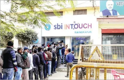  ?? DHIRAJ SINGH/THE WASHINGTON POST ?? Customers in line at a branch of In Touch, operated by State Bank of India, in Varanasi on December 9.